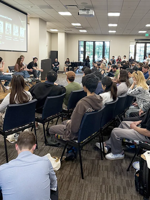 A packed room watching a humanoid robotics panel at the PrismaX salon during NVIDIA GTC